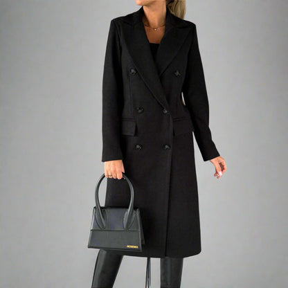 Zwarte winterjas voor dames, dubbele rij knopen, elegante lange mantel, gecombineerd met zwarte handtas en laarzen, modieuze winterkleding.